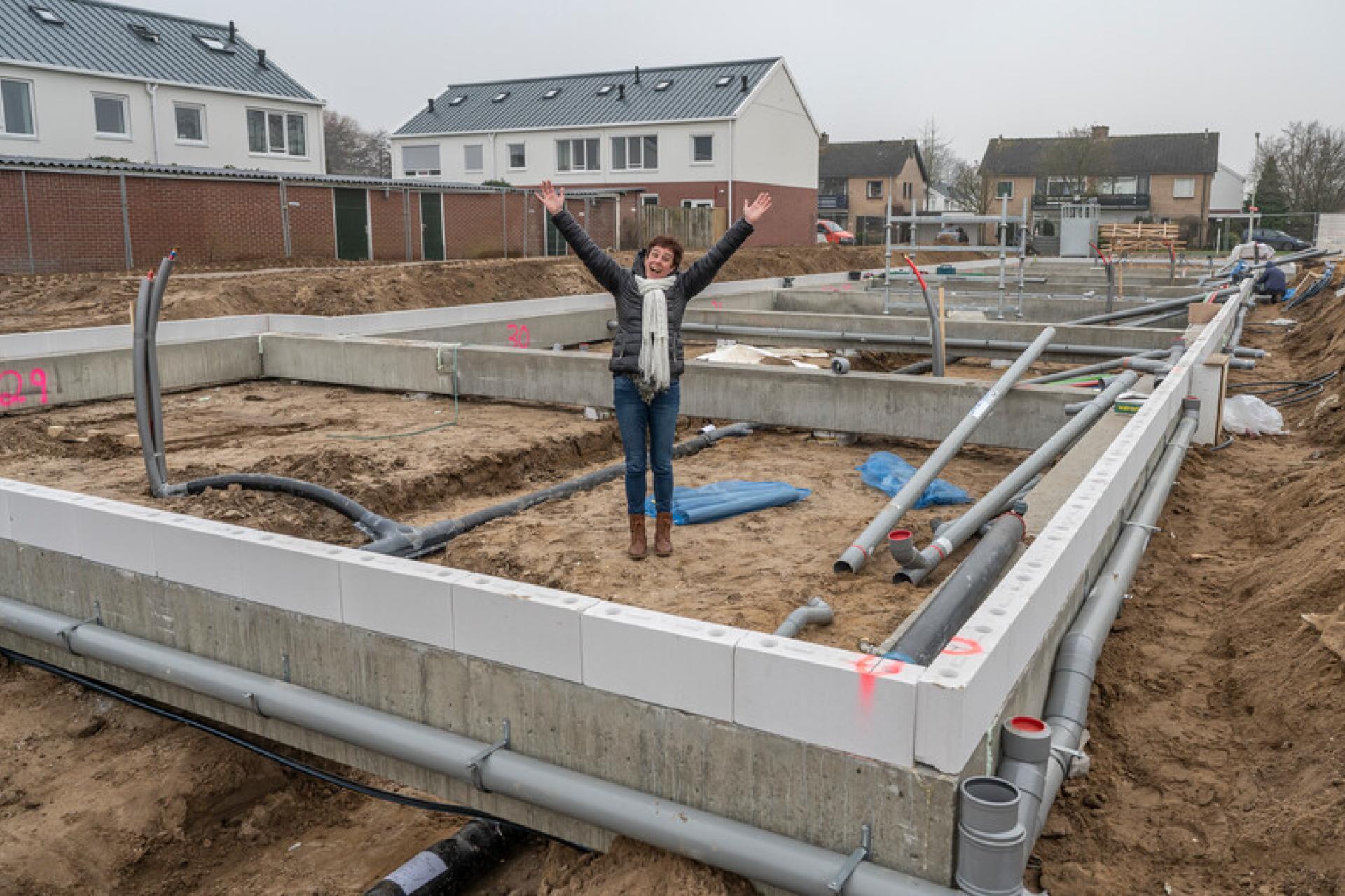 Vrouw op bouwplaats van haar nieuwbouwwoning